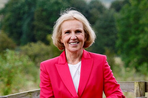 Susan Murray standing behind a fence