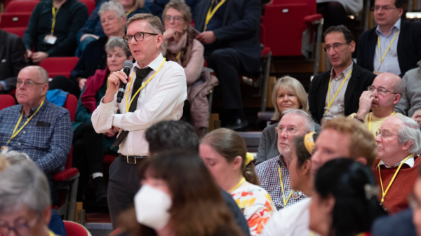 A member standing up to speak at conference