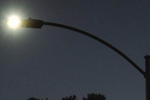 Silhouette of a switched on lamp-post in the dark