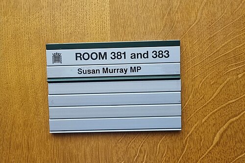 Sign on wooden door reading "Room 381 and 383. Susan Murray MP"